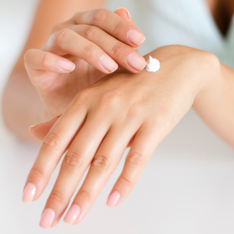 Close up su mani di donna curate. Sul dorso, della crema mani